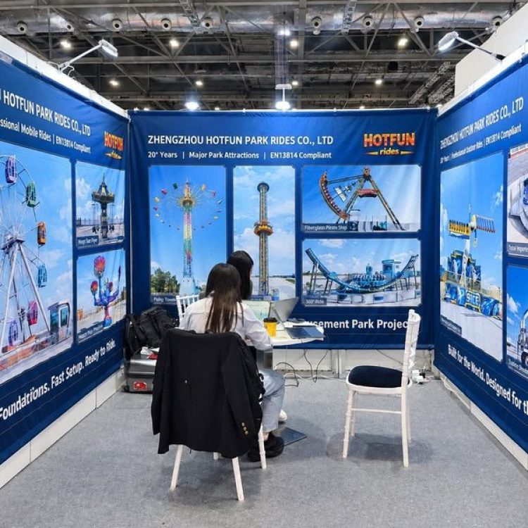 HOTFUN park rides exhibition booth showcasing ferris wheel, pendulum ride, and major amusement park equipment banners